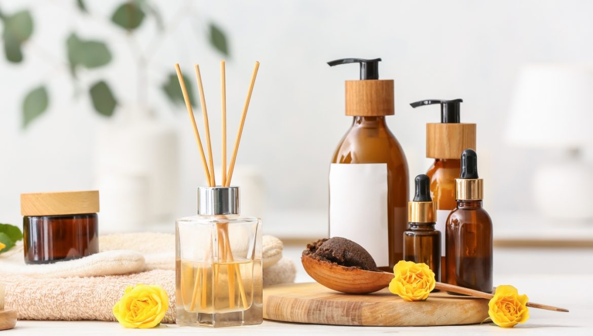 Domowe SPA - przepisy na sól kąpielową i kulki do kąpieli DIY. Zestaw SPA: kosmetyki w brązowych buteleczkach, rękawica do masażu i patyczki aromaterapeutyczne.