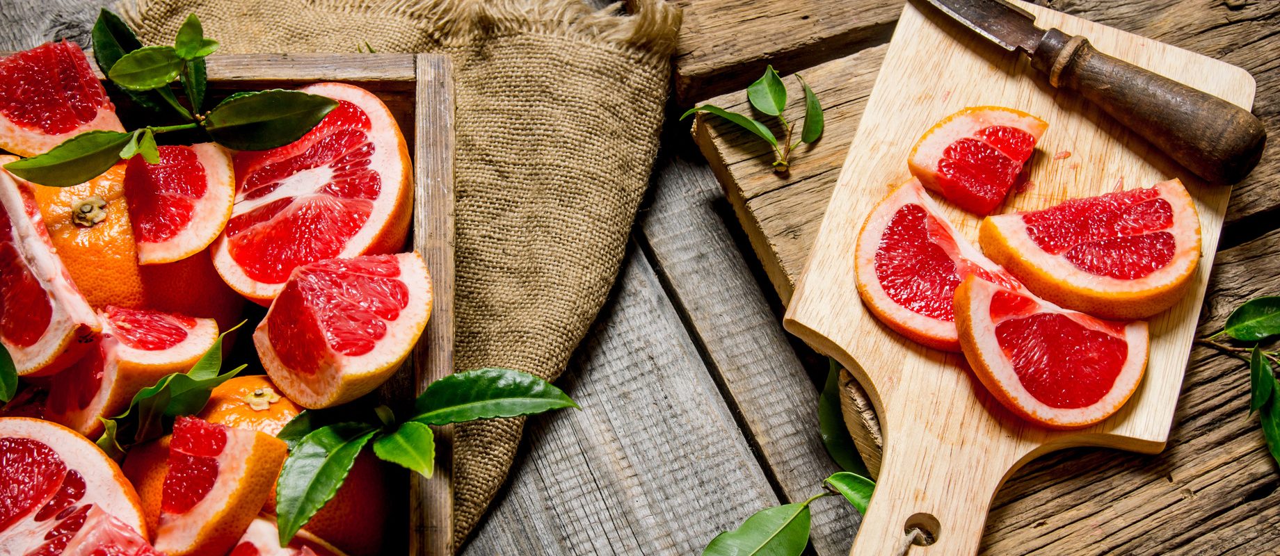 Grejpfrut w plasterkach na drewnianych deskach do krojenia. Jak zrobić napar z grejpfruta (herbatkę z grejpfruta) na przeziębienie?