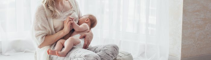 Karmienie piersią - fakty i mity. Kobieta karmi niemowlę piersią.