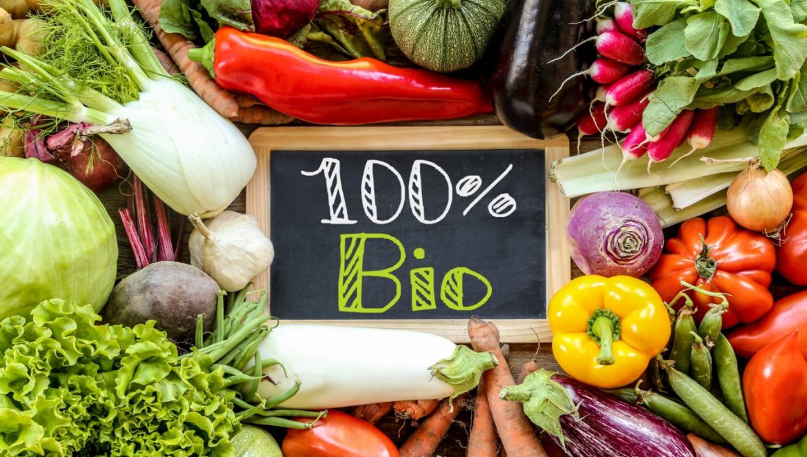 Nie wszystko, co bio, jest eko. Jak nie trafić na fałszywkę? Warzywa ułożone wokół tabliczki z napisem 100% Bio.