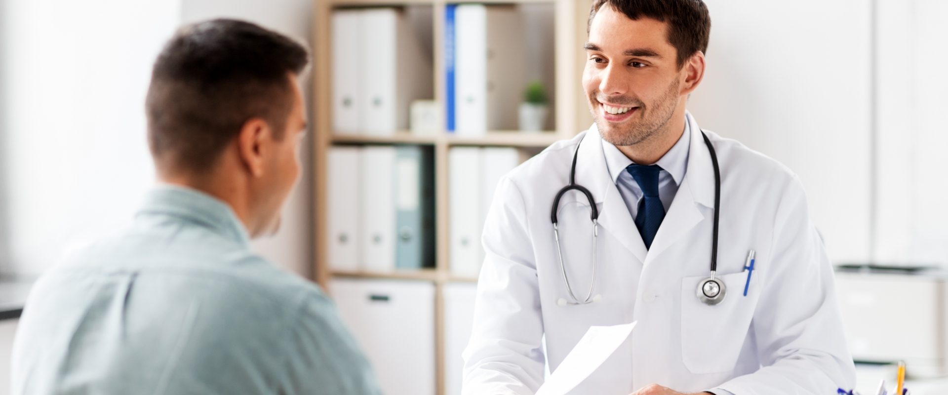 Niepłodność u mężczyzn - jakie są przyczyny i jak ją leczyć? Lekarz przekazuje pacjentowi diagnozę w gabinecie lekarskim.