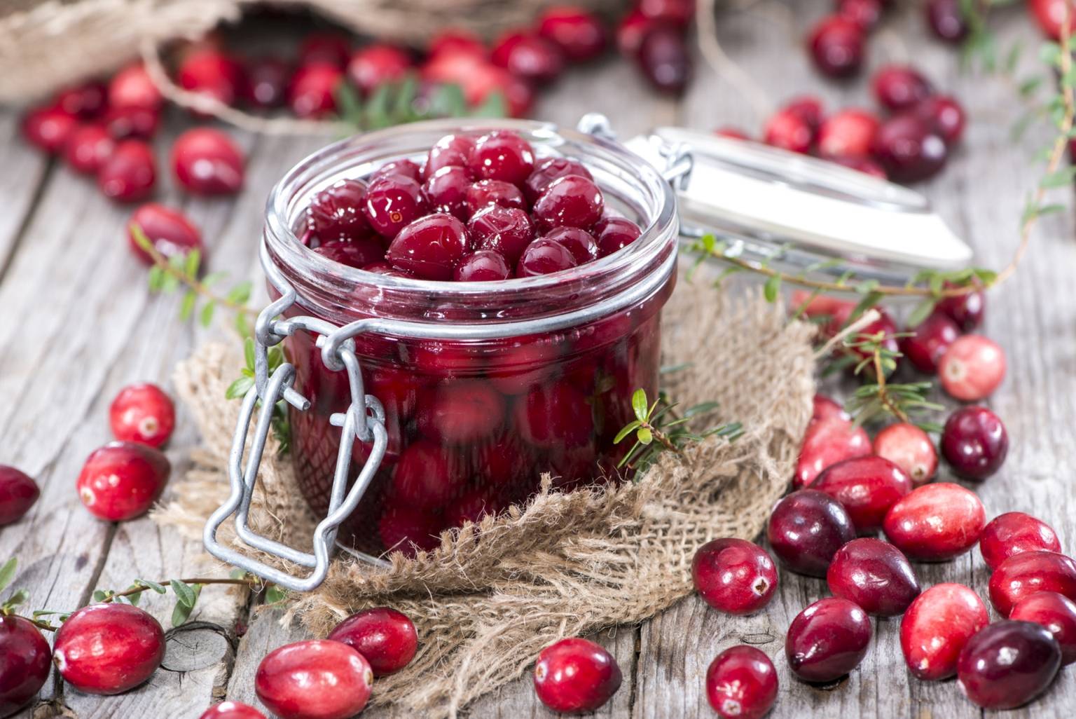 Owoce świeżej żurawiny w słoiczku. Żurawina pomaga na zapalenia dróg moczowych.