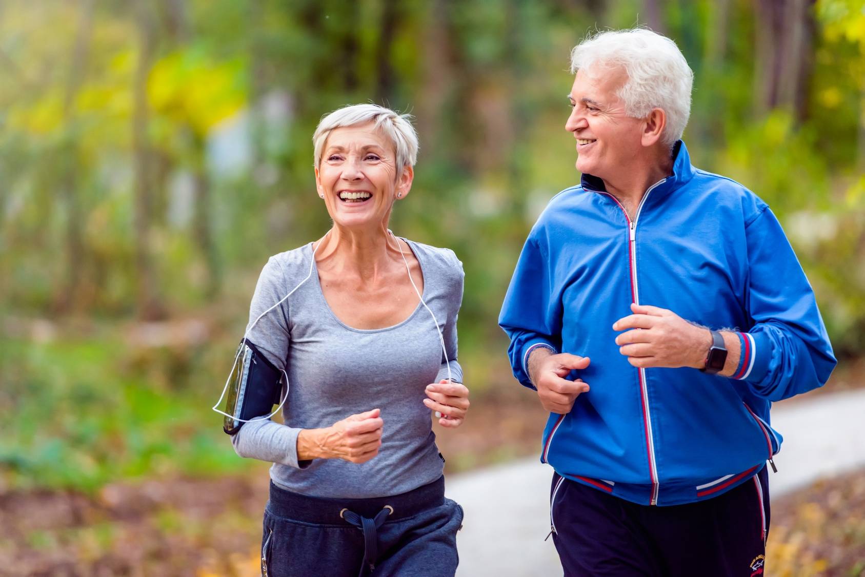 Suplementy wapnia - czy mogą zapobiec osteoporozie? A może są niebezpieczne dla zdrowia? Para seniorów uprawia jogging w parku.