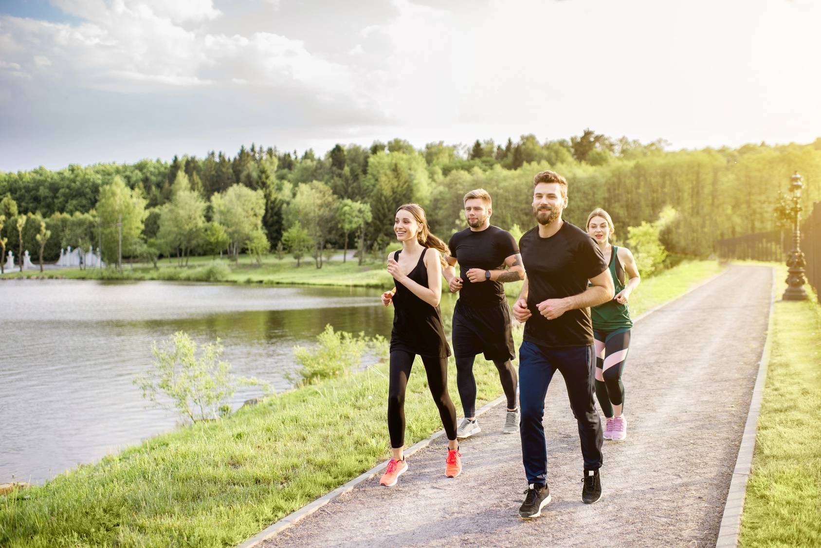 Grupa młodych ludzi uprawia slow jogging na świeżym powietrzu.