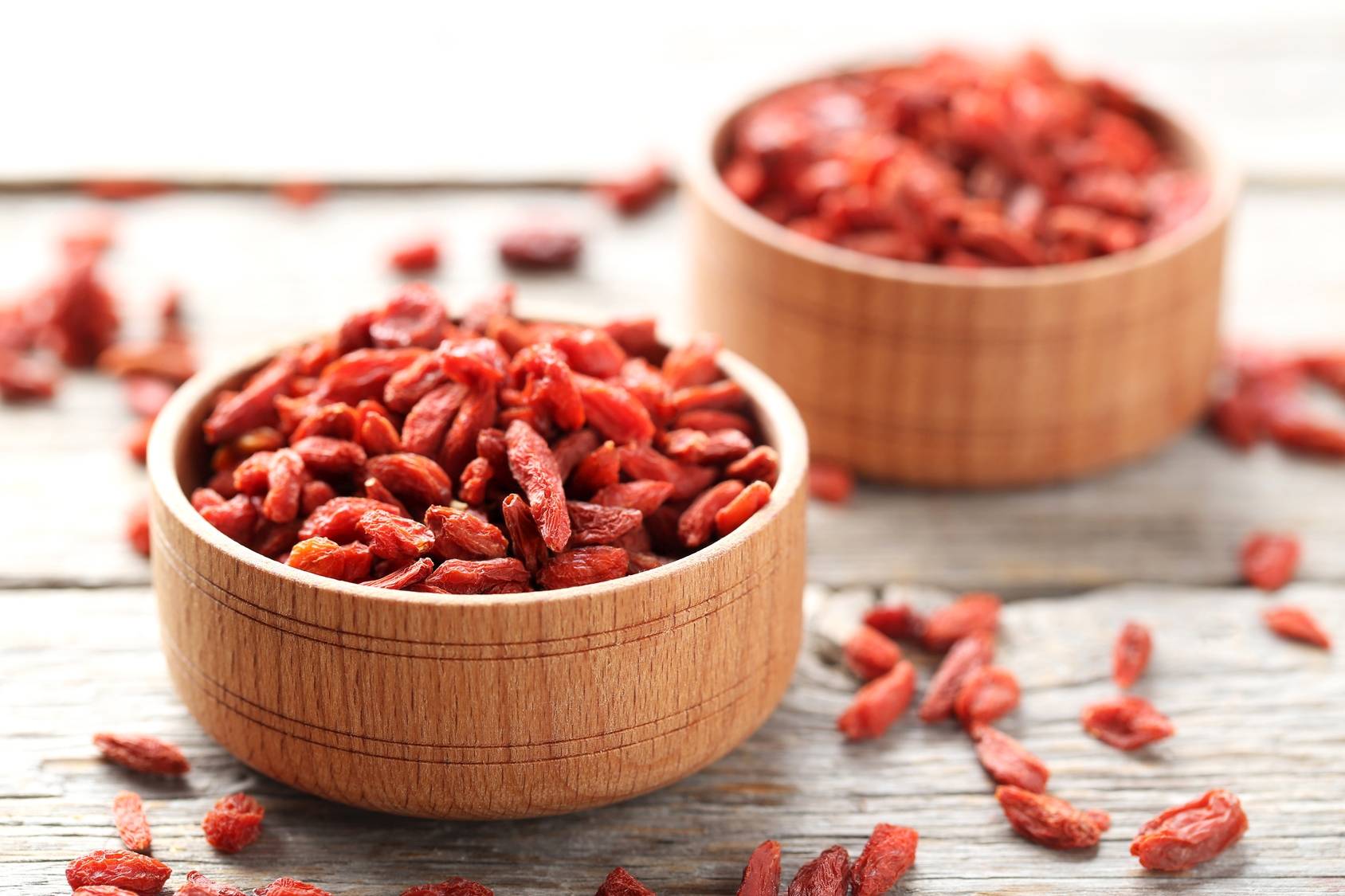 Jagody goji - przeciwwskazania do stosowania. Suszone owoce goji w drewnianych miseczkach.