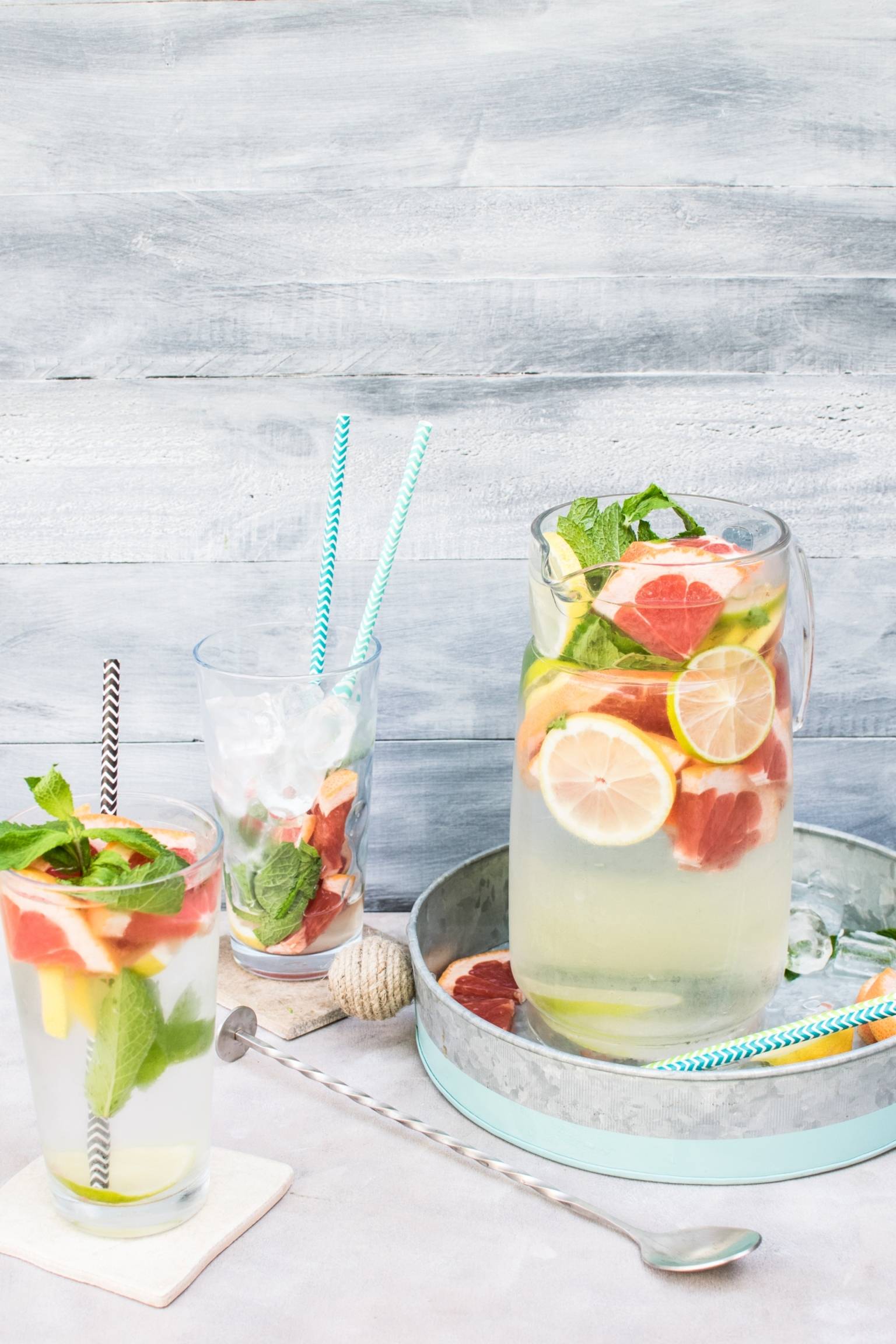 Owocowa lemoniada w dzbanku i szklankach z dodatkiem cytrusów i lodu. Ile wody pić latem? Co pić w upały?